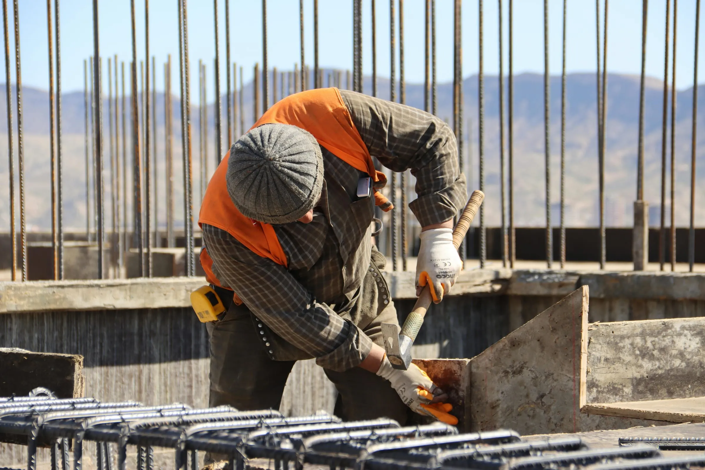 A builder tying reinforcing steel on site