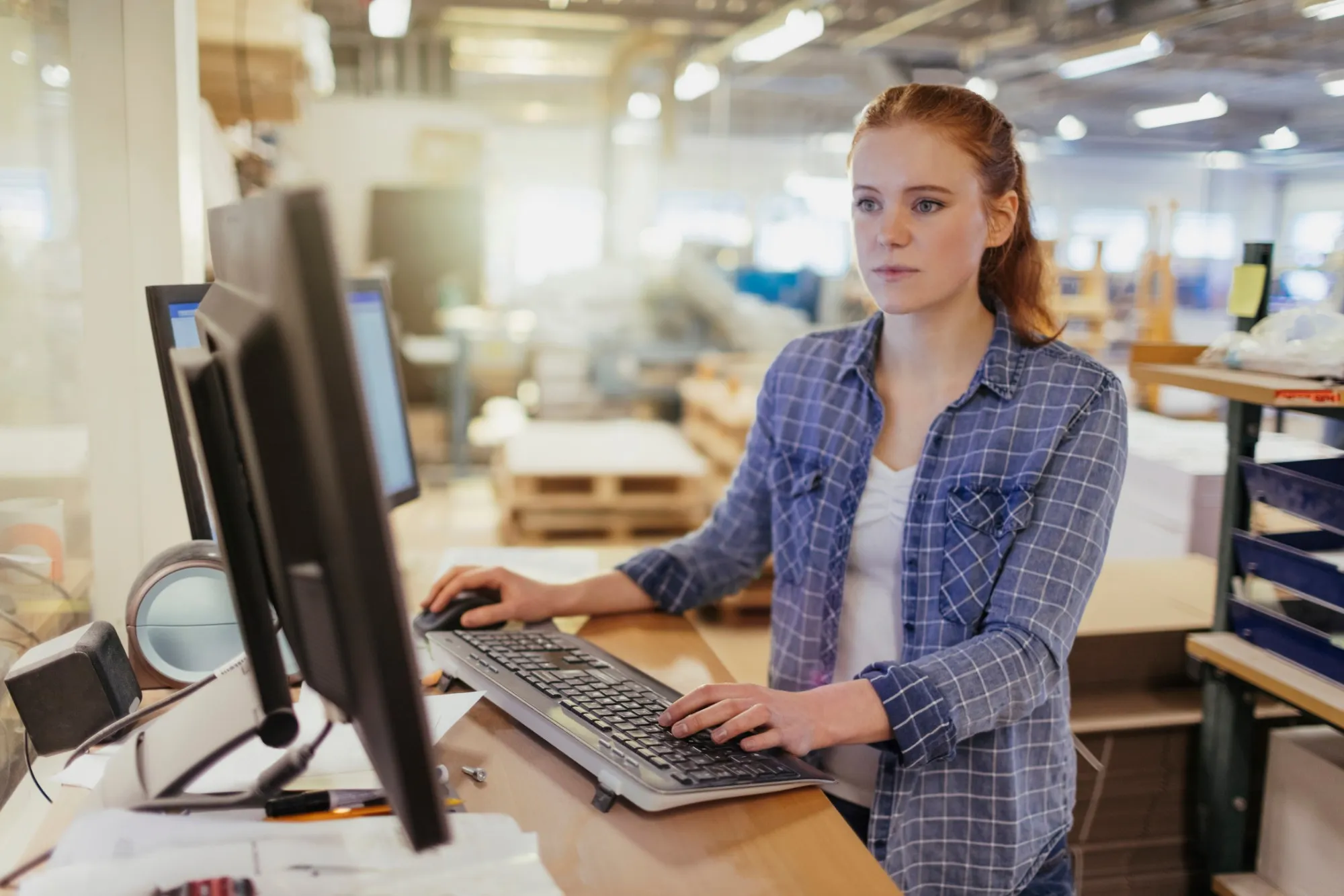 An operations coordinator at her desk on the warehouse floor
